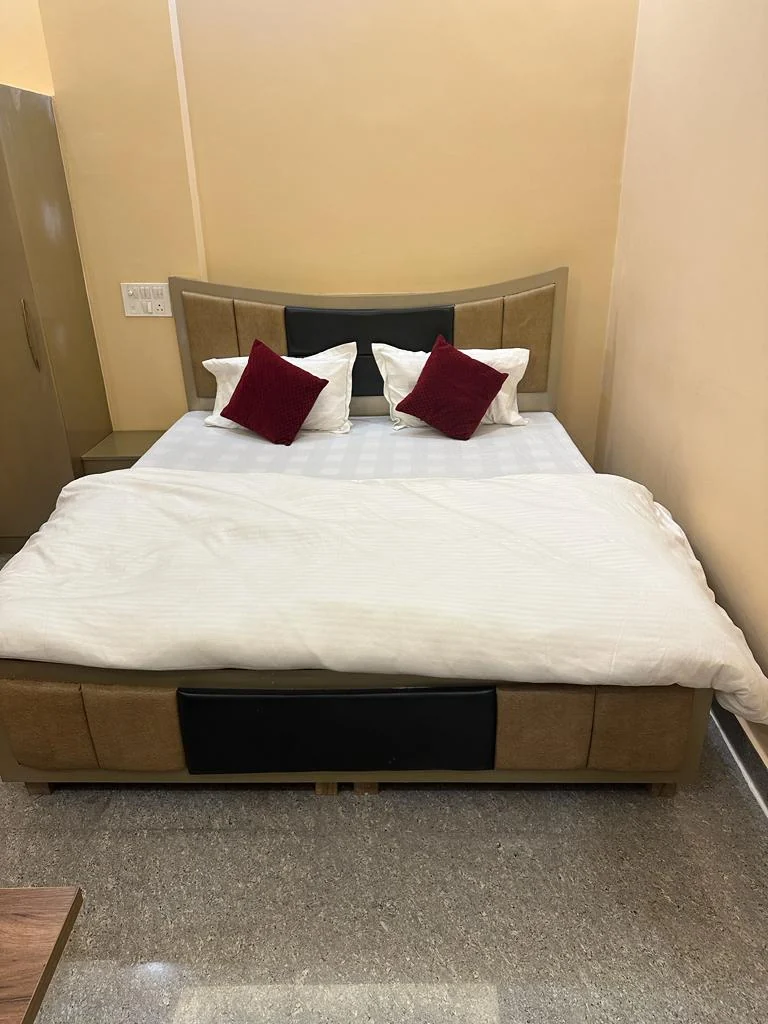 Neatly made double bed in a Hotel Sunshine room